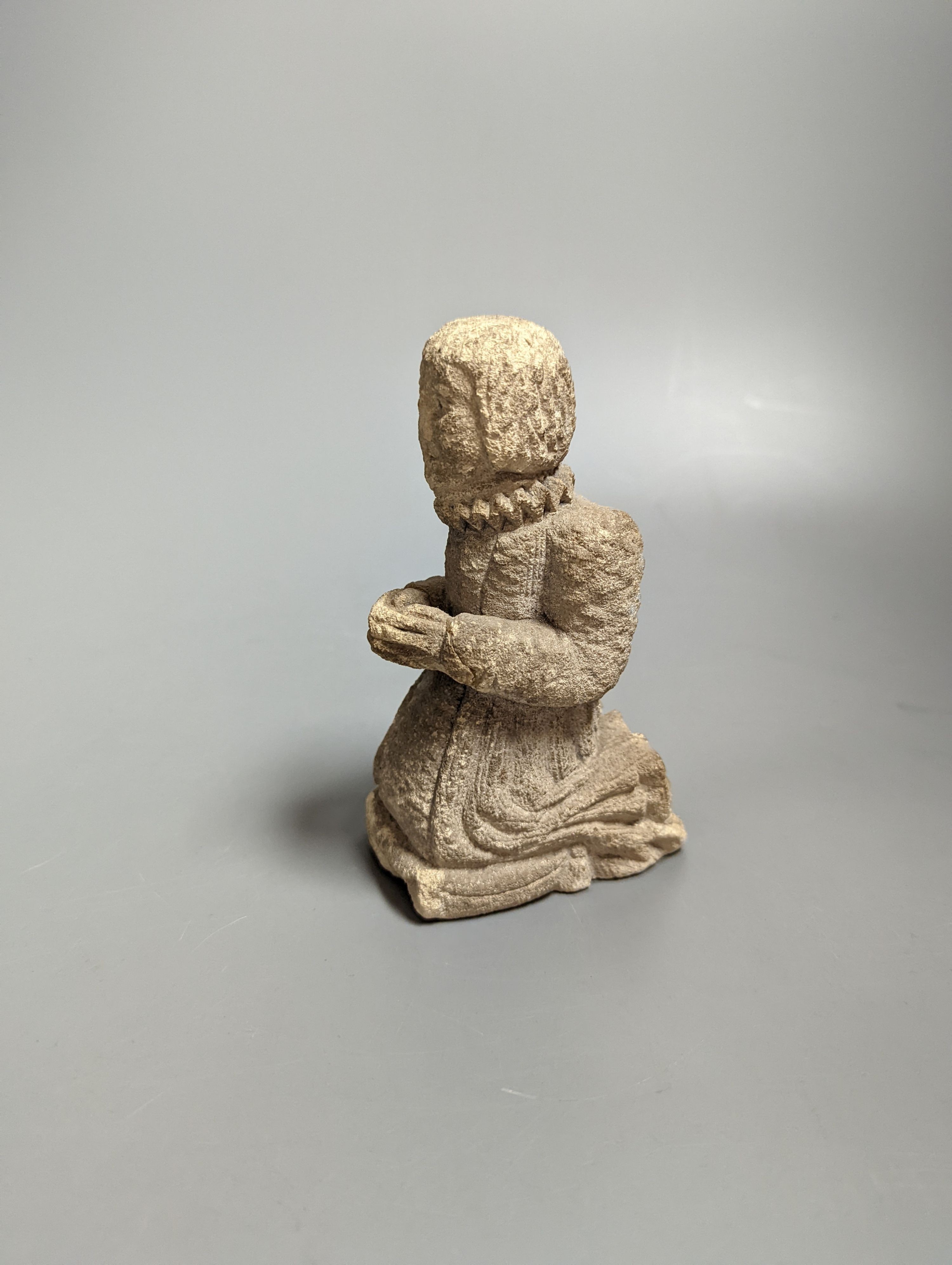 A small carved limestone kneeling/praying chorister, possibly Medieval, 13.5 cms high